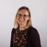 Based in Bristol, Somerset, ILS Case Manager Anna Stangroom, wears glasses and a floral shirt and smiles warmly at the camera.