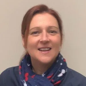 Louise Ainger, an ILS Case Manager based in Hereford, Herefordshire, is wearing a blue and red scarf and a blue top.