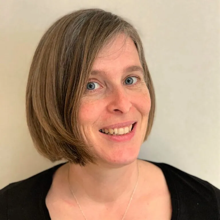 Headshot of Susie Quinlan, ILS Head of Case Management, featuring a woman with short hair wearing a black top.